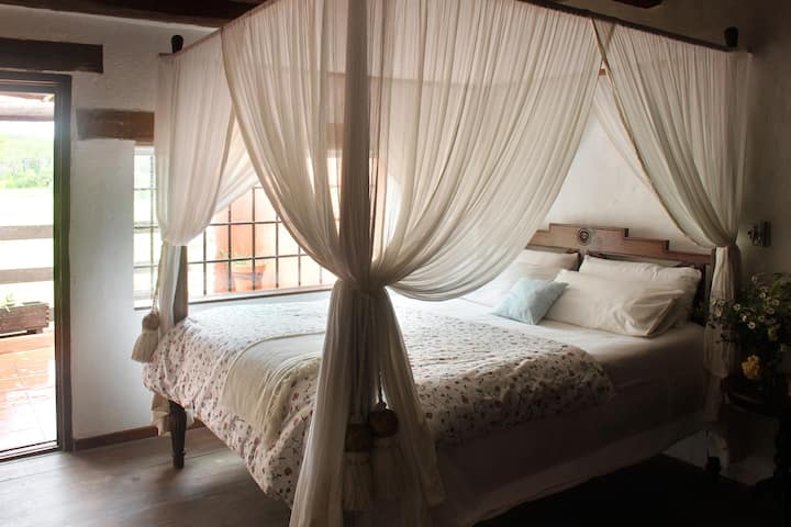 Très belle chambre avec lit double et accès à un balcon.