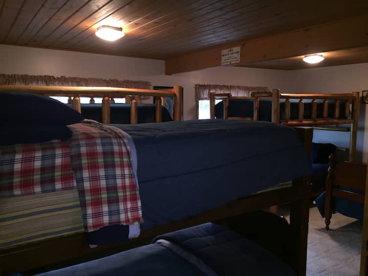 ห้องนอนด้านหลังมีเตียงและเตียงสองชั้นมากมายเพื่อรองรับผู้เข้าพักจำนวนมาก 