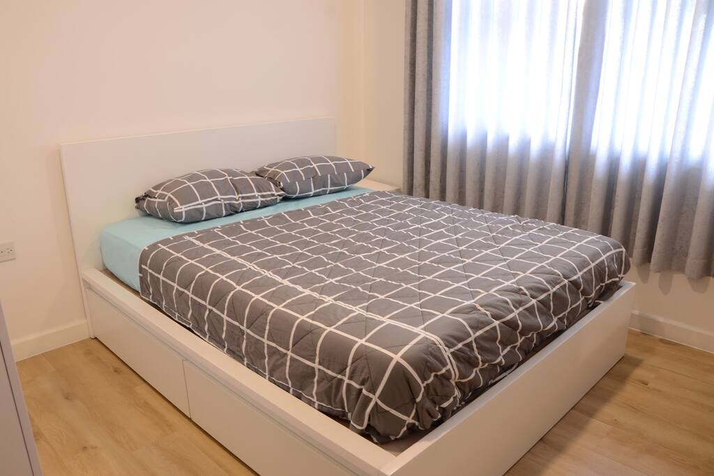 View of the first queen bedroom with shelves & wardrobe