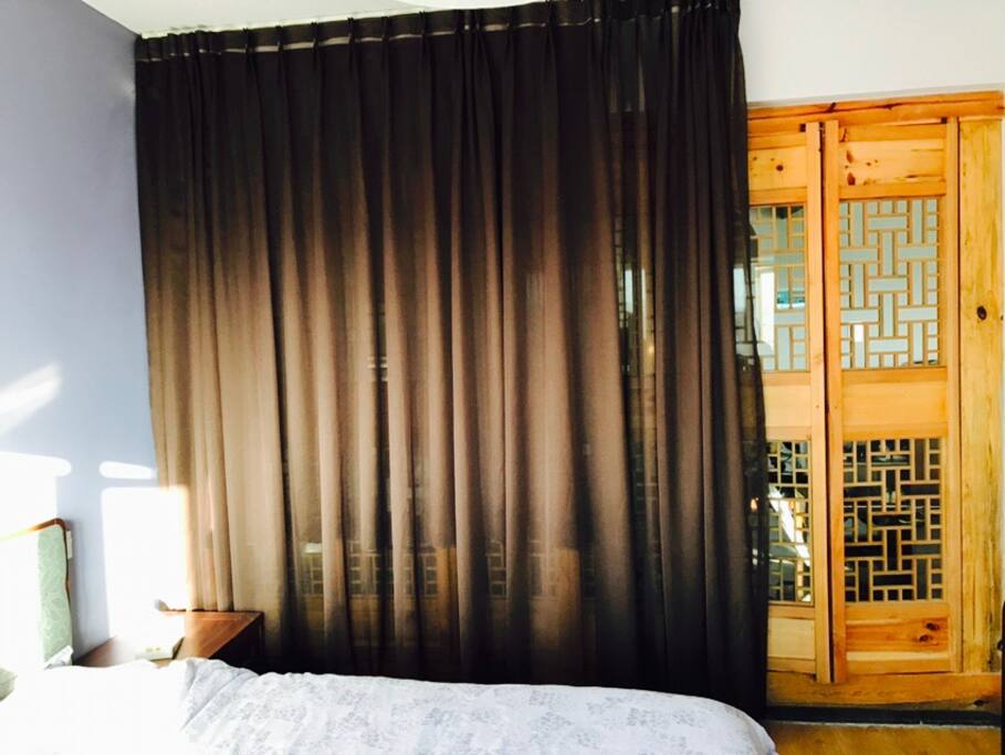 The bedroom door takes up the whole wall, as you can see, the wall (door) is wooden with glasses-framed.