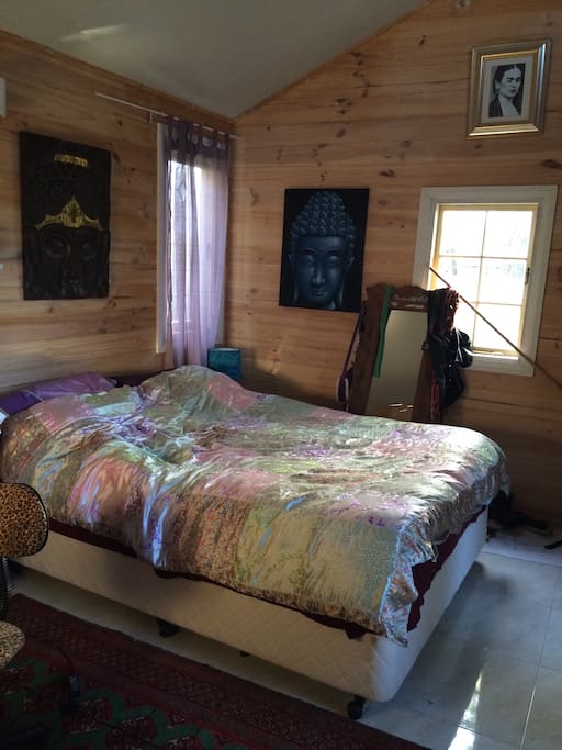 The whole cottage is panelled in pine. The main bedroom has really high ceilings with a beautiful leafy outlook and lots of light. It's z beautiful, peaceful room to wake up in.
