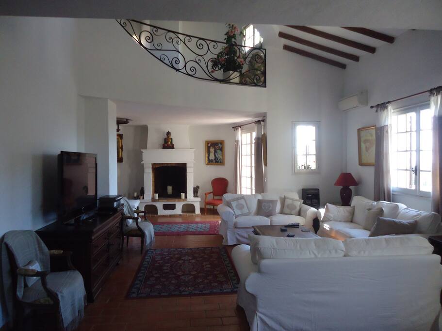 Sitting room with fireplace, mezzanine accessed by spiral staircase and french windows opening onto the terrace