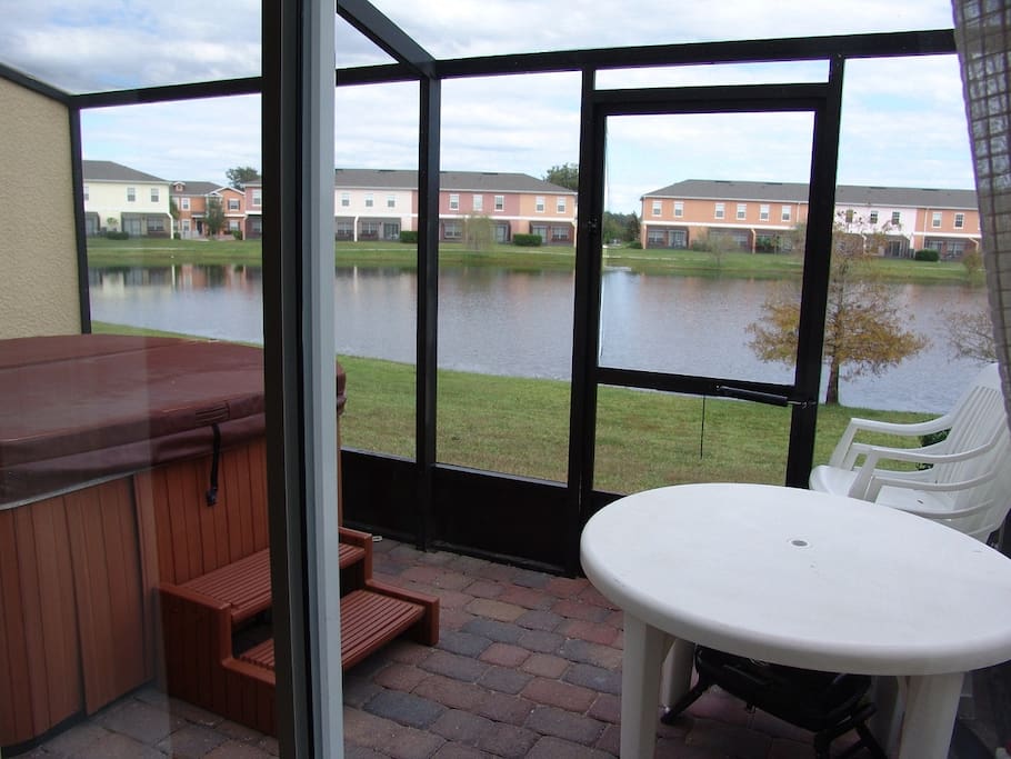 screened rear patio with hot tub and lake view.