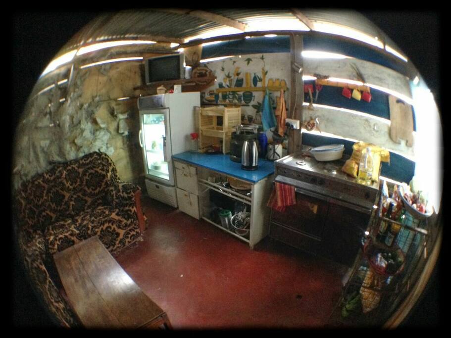 The kitchen is still under construction (the walls) but equipped with utensils, a single gas cooker and a water boiler. Water tap outside. Comfortable sofas and a small TV.