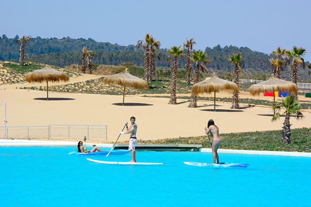 Playa artificial, con salvavidas y actividades guiadas para niños y adultos.