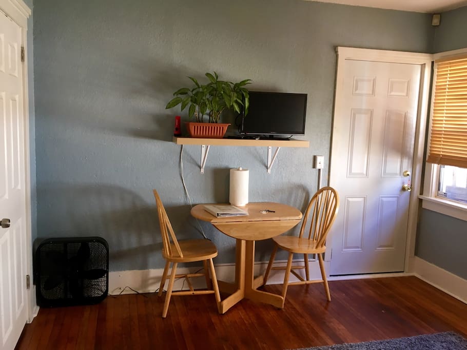 Living room area with private entrance, closet, table, and television with Roku.