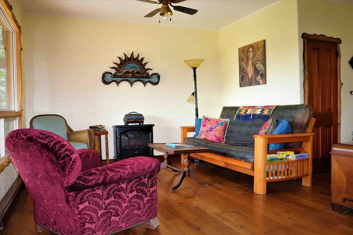 Un enorme ventanal ofrece impresionantes vistas desde esta acogedora sala de estar.  Con un rico suelo de madera y una decoración de buen gusto, los cómodos muebles son perfectos para acurrucarse con un buen libro o descargar una película o un podcast, utilizando el excelente wifi.