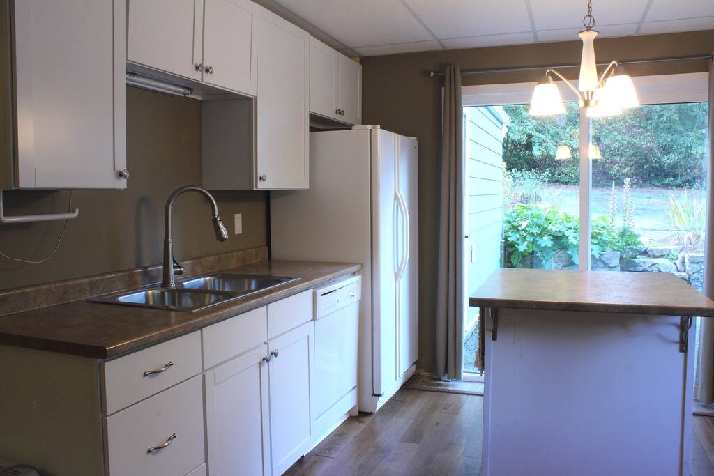 Kitchen, with view of private patio through sliding glass door.