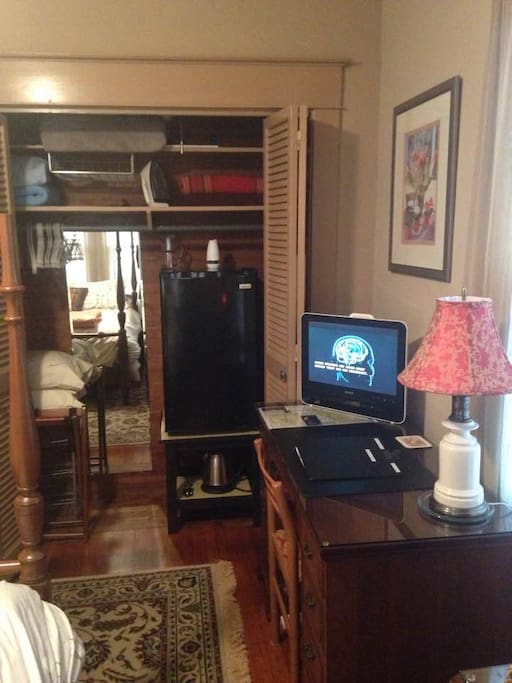 Large lighted double closet in the bedroom, features - hangers; iron/ironing board; full length mirror; laundry basket; drying rack; and extra bedding items. In addition, a half-size refrigerator is tucked *quietly* into the oversized closet.
