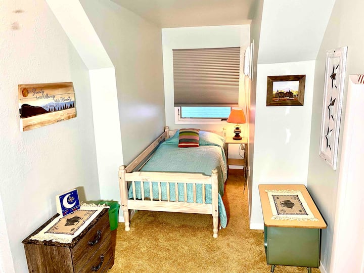 Au milieu supérieur, la chambre dispose d'un lit Queen Size et d'un lit jumeau avec une salle de bain 3/4 à côté. 