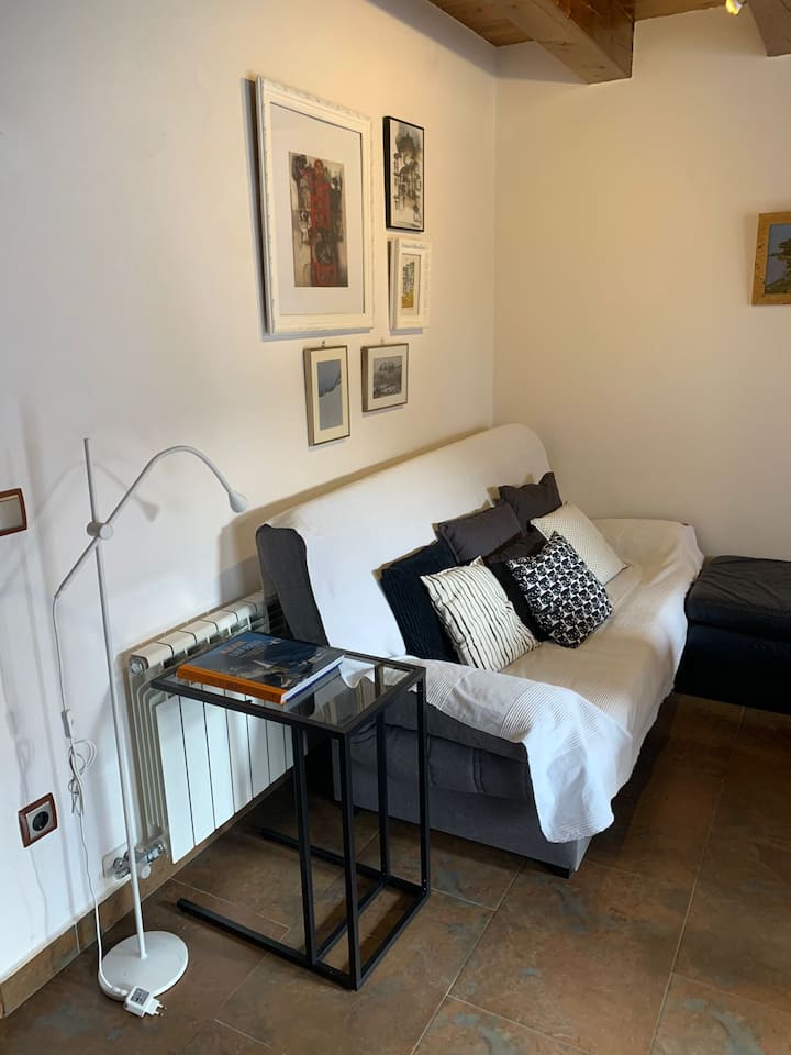 Диван и компютърна маса с книга над Вале де Аран. В трапезарията