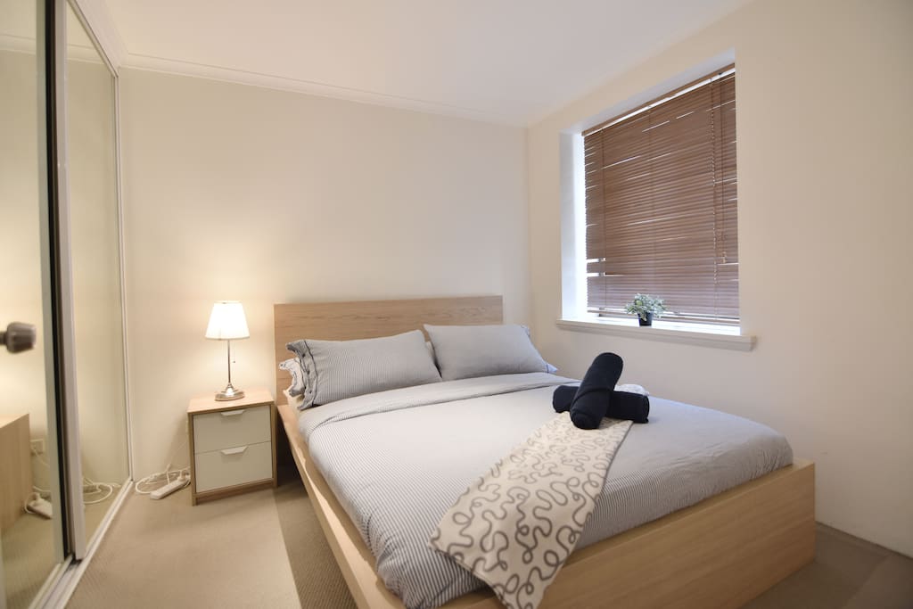 A bedroom with a queen sized bed with plush pillows.