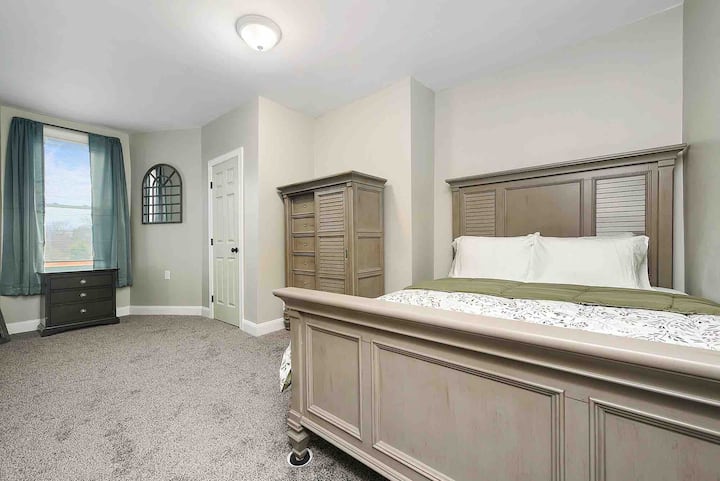Amplio dormitorio principal abierto con sábanas y cortinas limpias