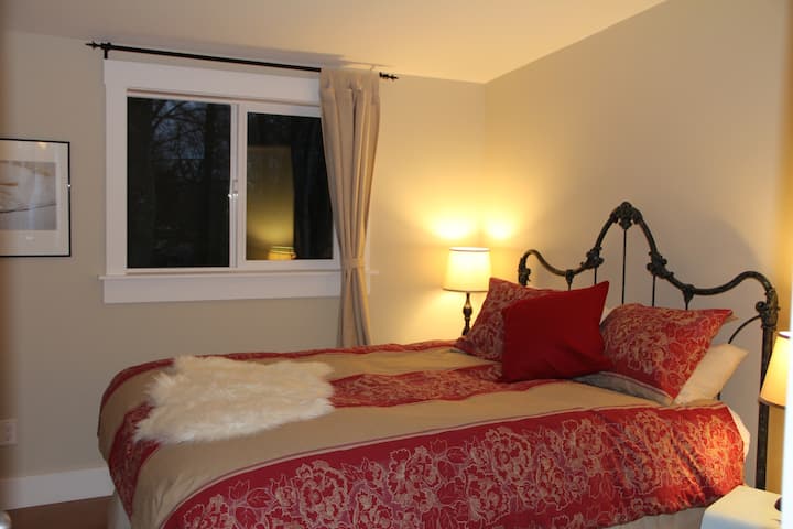 Cozy bedroom with queen size bed and access to private garden patio.