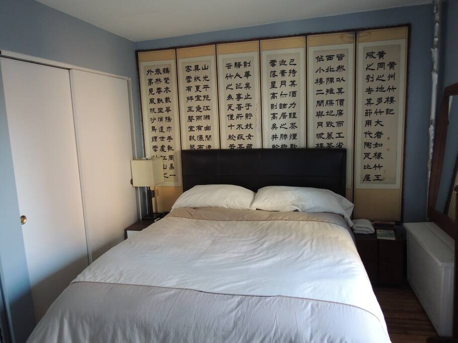 large bedroom with queen bed and tons of light