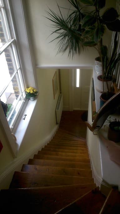 Main door access and beautiful varnished stairs leading to the main floor