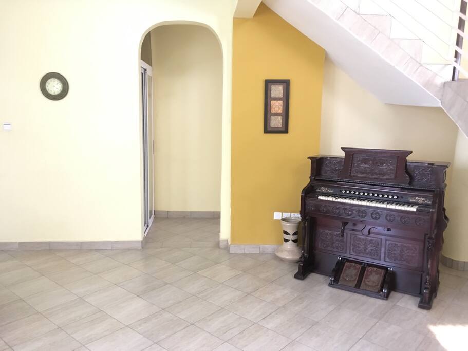 Second living room with piano and contemporary cain chairs.
