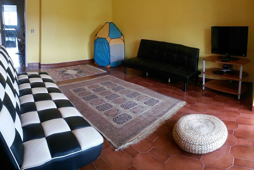 Sala com LCD, TV cabo e mini parque para crianças.
