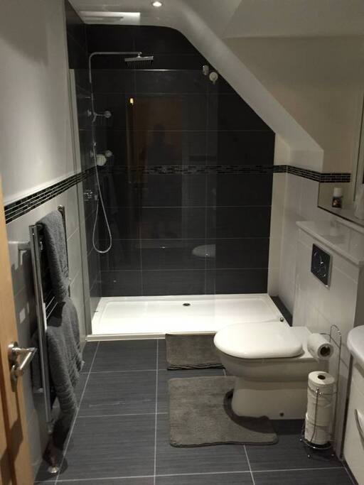 ensuite bathroom with shower, storage cupboards and towels included
