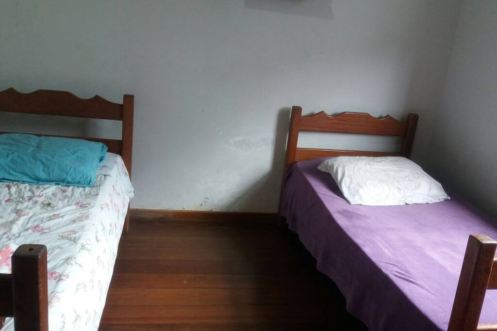 Quarto duplo ventilado, com duas cama de solteiro, escrivaninha e capacidade máxima de 4 pessoas (1 beliche e 2 chão)