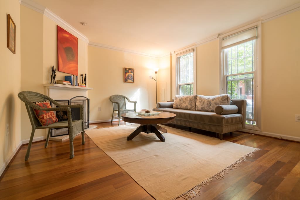 Spacious, sunny living room (couch converts to comfortable queen bed). Teak hardwood floors, wood-burning fireplace.