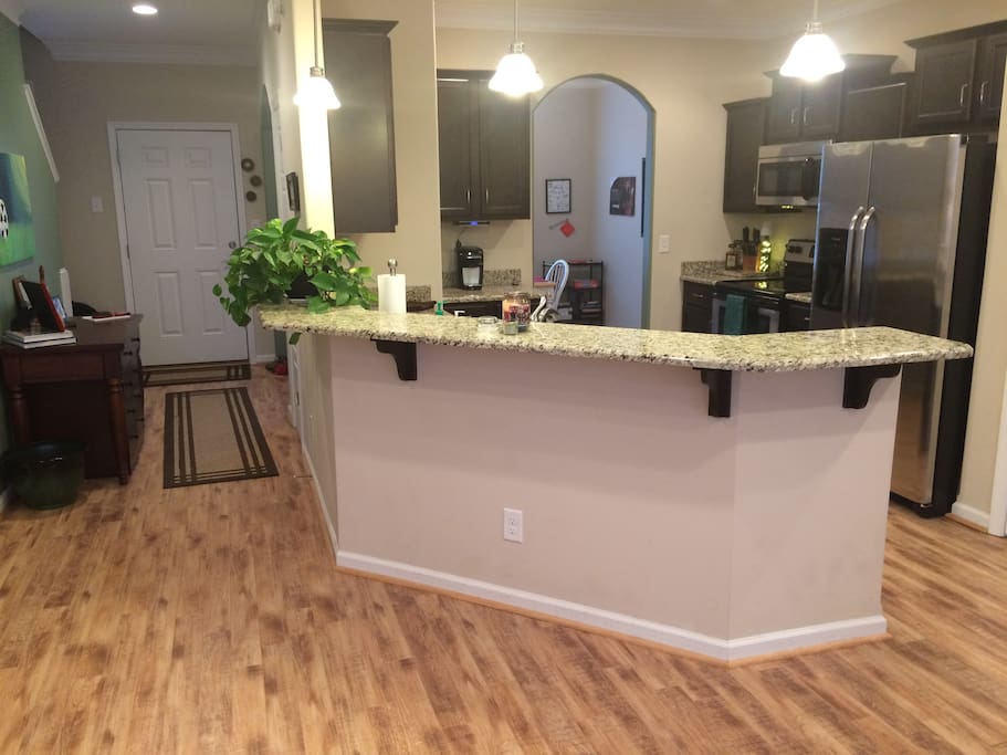 View of the front door, front hallway, and kitchen.