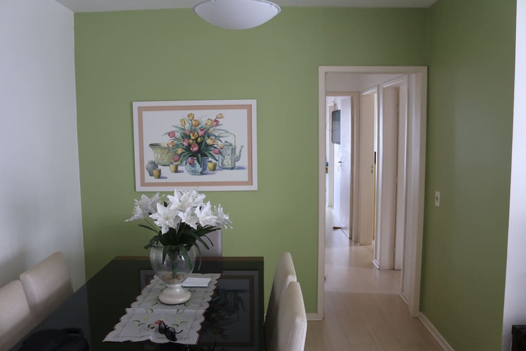 Entrada do apartamento com uma mesa que acomoda 6 pessoas.