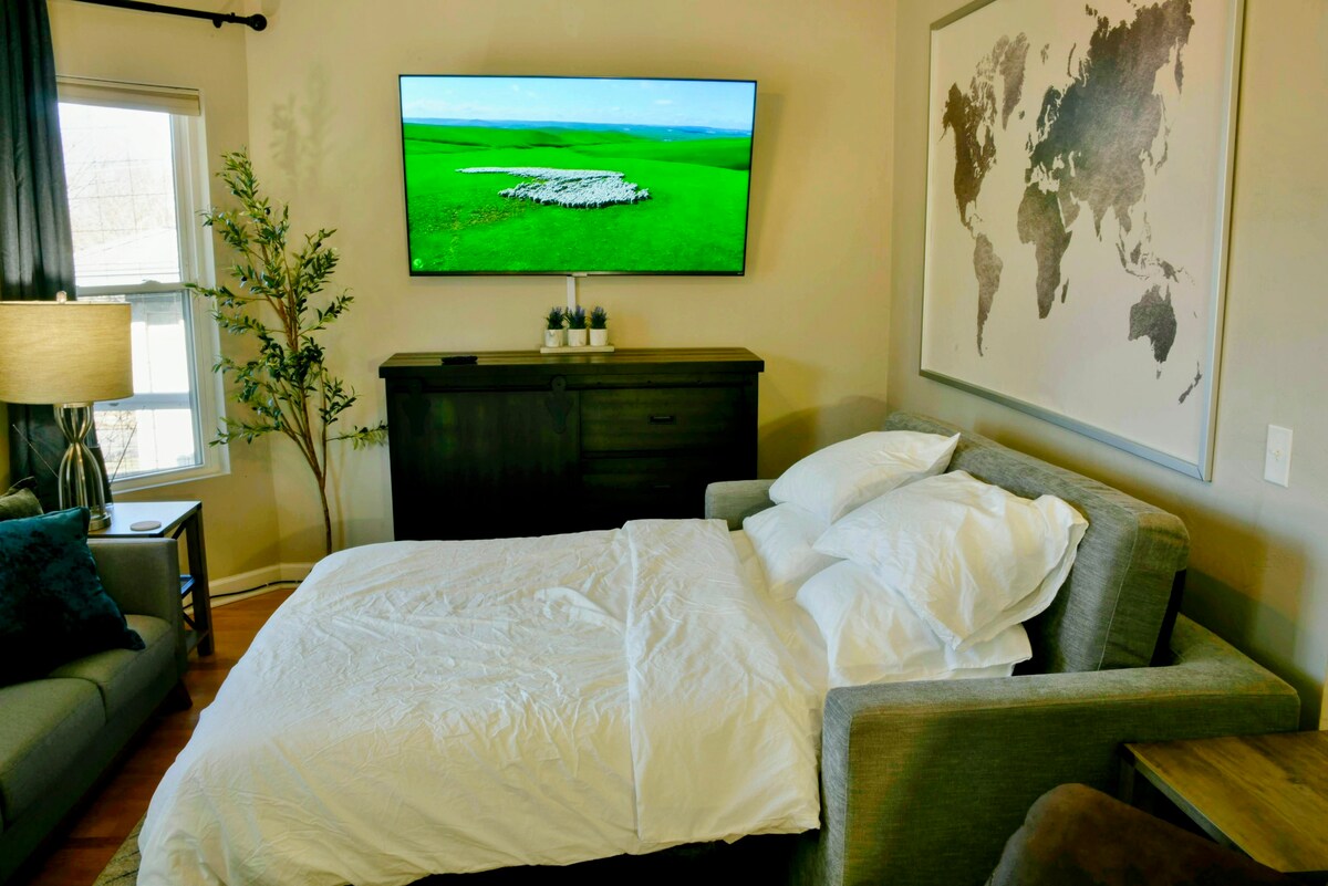 客厅配有舒适的标准双人沙发床和65英寸4K Roku电视。 两张较小的边桌都配有USB-A插头和插座。 两张较大的边桌均配有USB-A端口和插座。 电视下方的橱柜里有各种游戏和拼图。