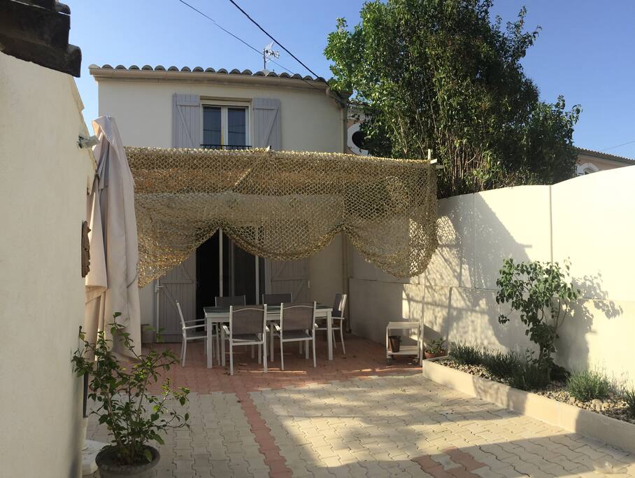 Vous entrez donc dans la cour qui est l'extérieur où vous pourrez prendre vos petits déjeuners, déjeuners ou dîners. C'est une table à rallonges pour 10 personnes si vous avez des amis dans le coin...