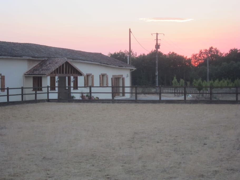 Sun set behind the house & horse sand arena.