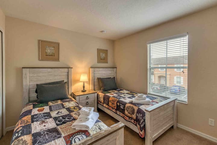 Deuxième de deux chambres avec deux lits jumeaux et une télévision à écran plat.