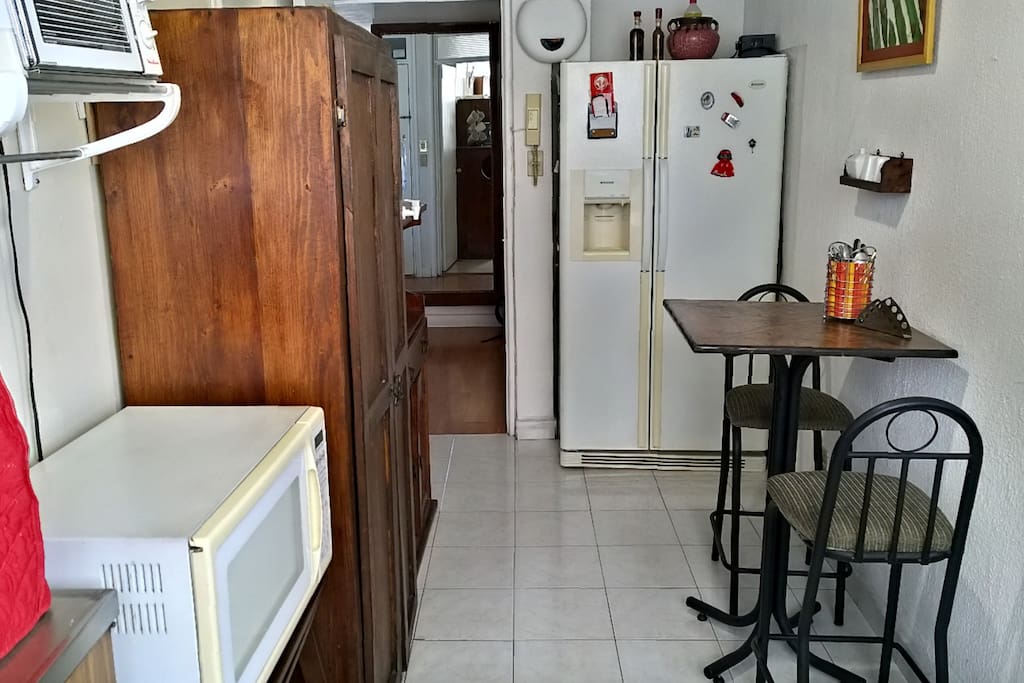 Fridge, microwave and breakfast table at the kitchen.