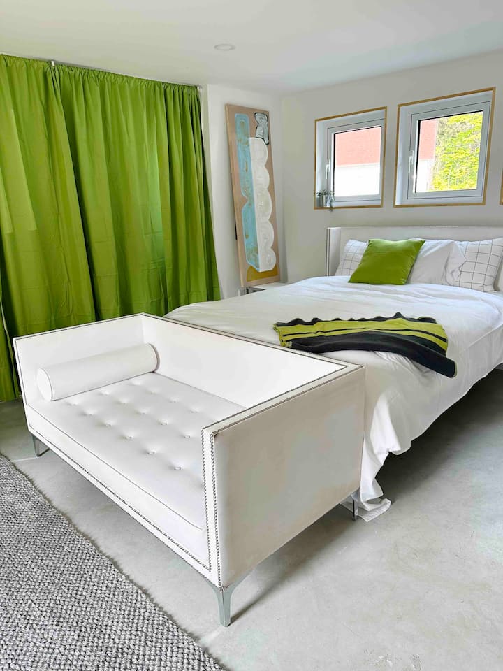 Downstairs bedroom. Curtains open to large windows and a balcony