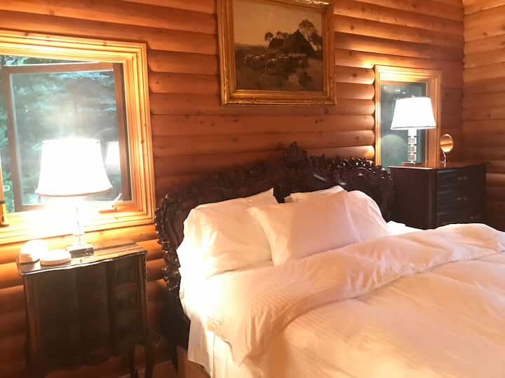 主卧配有雕刻木制家具、梦幻羽绒被和带大按摩浴缸的套内卫生间。