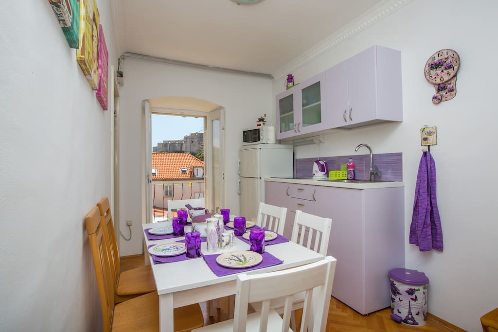 Dining area with kitchen, shared with other tenants, opens to balcony