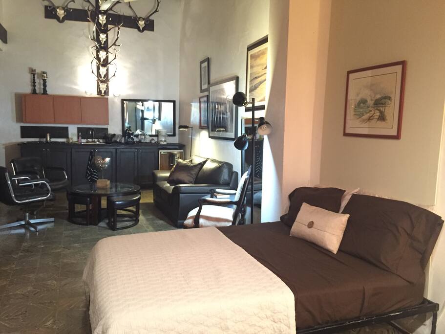 Full size bed, living room area, stovetop, small oven, small fridge. Ceilings about 18' high.