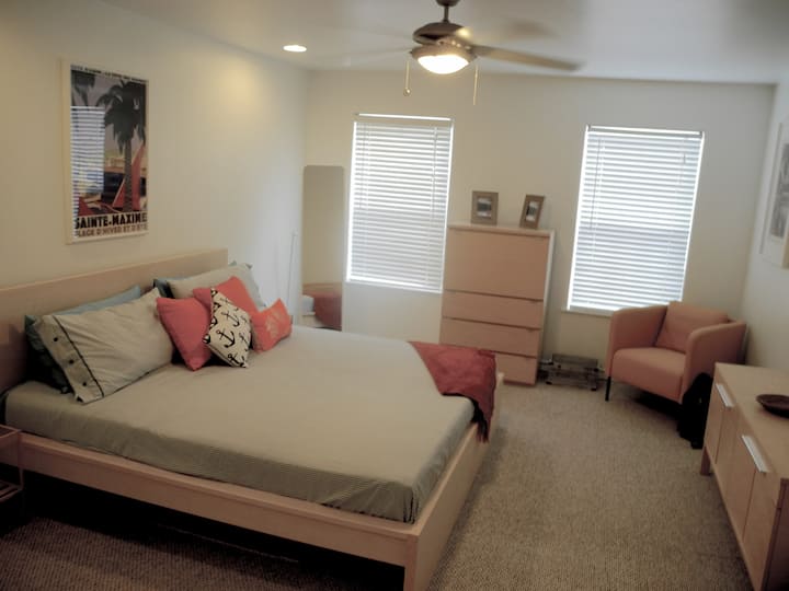 Dormitorio principal con una cama tamaño king y una puerta al baño principal.