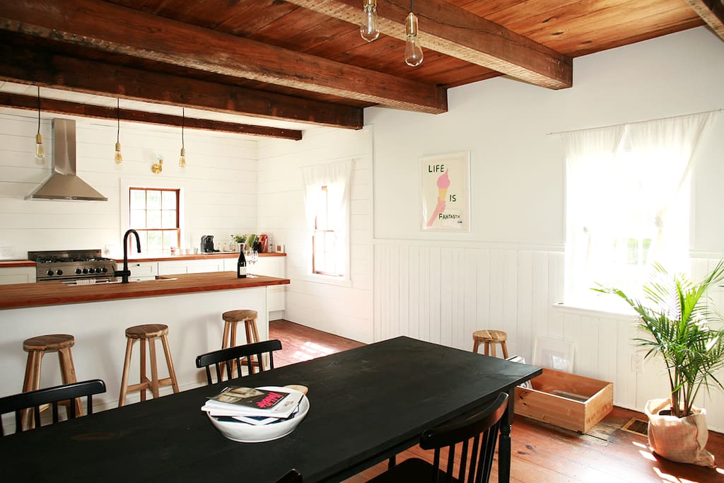 A fully renovated chef's kitchen and dining room with windows on all sides.