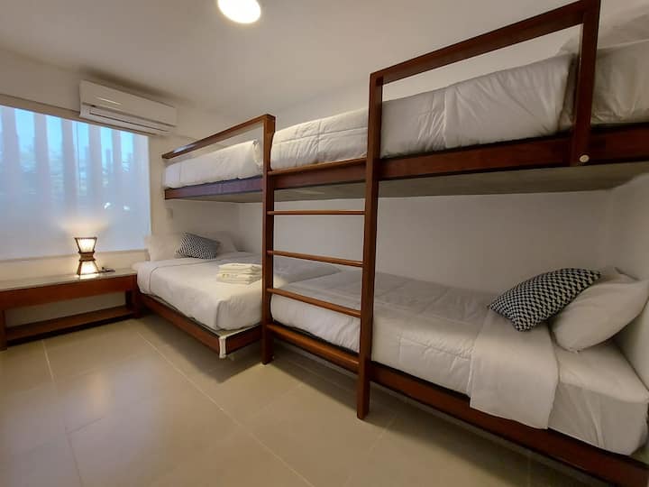 Dormitorio secundario con 1 cama de 2 plazas y 3 camas de 1 plaza y media.