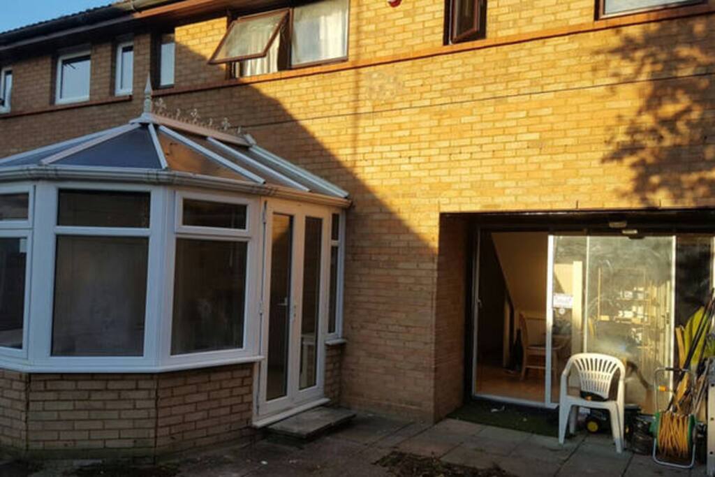 Spacious basic garden space with patio and conservatory.