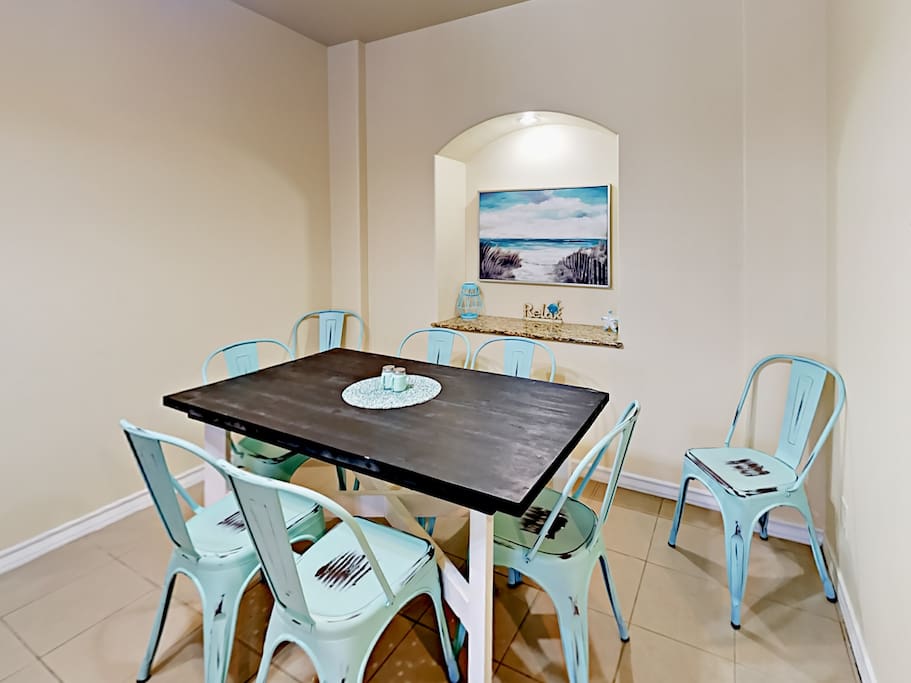A beachy dining area has seating for 8.