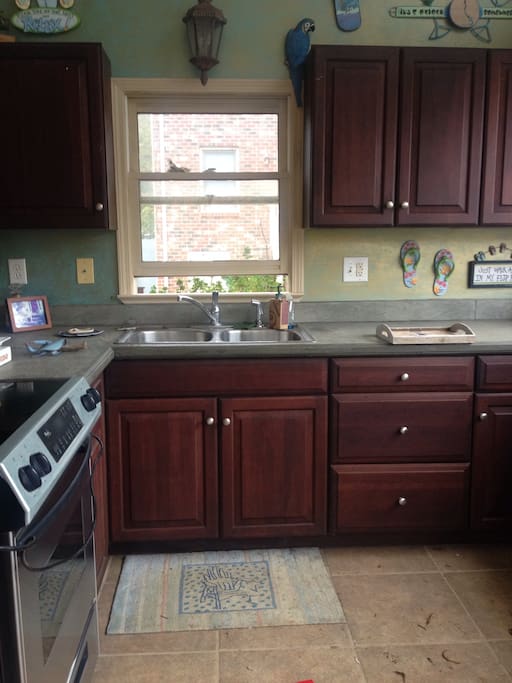 Outdoor kitchen has full size range, mini refrigerator and 2 bin sink.