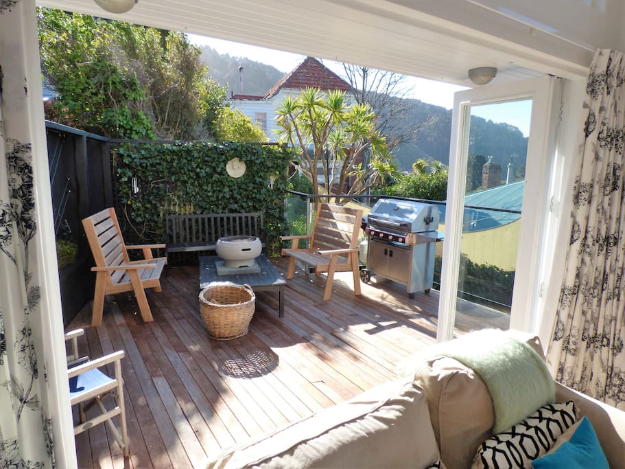 Private sunny sheltered deck of sitting room with view of city