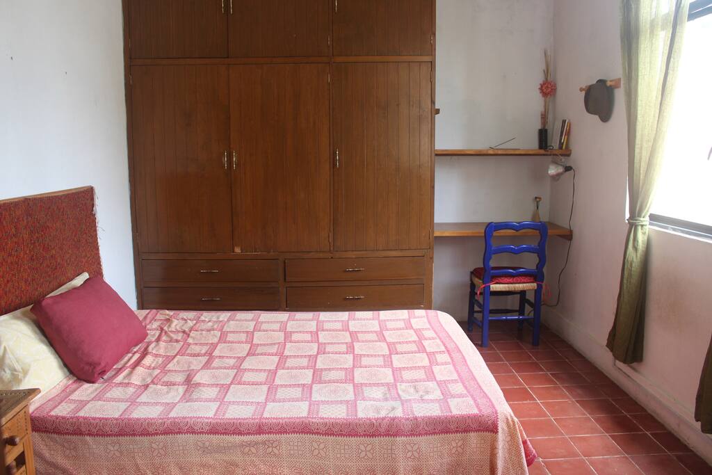 Cama matrimonial, área para trabajar y guardarropa
