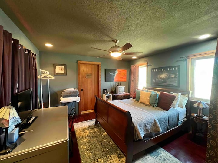 Third bedroom upstairs with queen bed, desk and TV. The air mattress and bedding are stored in this room. Also, has a window over looking the living room area and a window looking into the entry way.