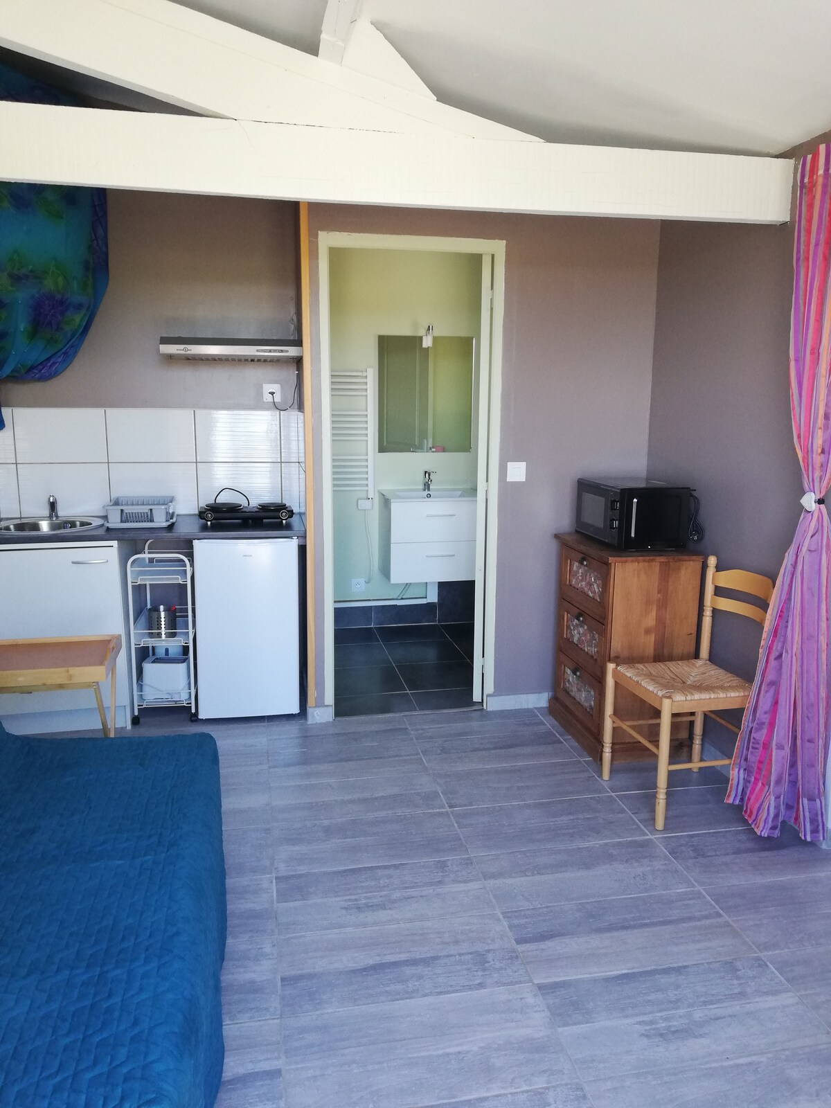 living room with sofa bed, small kitchenette, at the back bathroom and toilet, on the right door to the cottage/bedroom