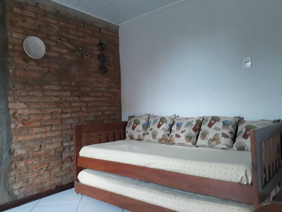 Sala com uma bicama. TV .