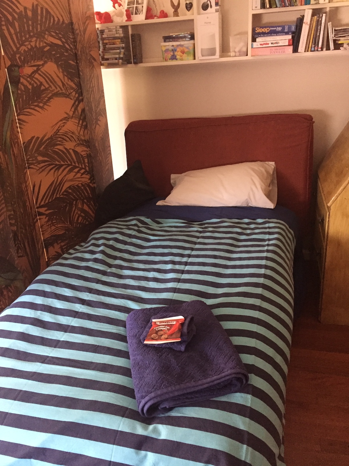 Cama de repuesto hecha en la esquina de la sala de estar con un divisor de pared para la privacidad. Utilizo la otomana que vive en la esquina para que el colchón esté en el suelo. Esta es una solución ideal si tienes 4 adultos alojados que cada uno quiere su propio espacio y privacidad. 