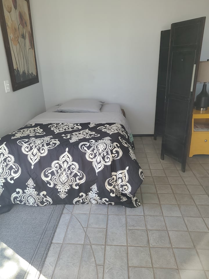 Living room has a roll-away bed with a room divider if needed