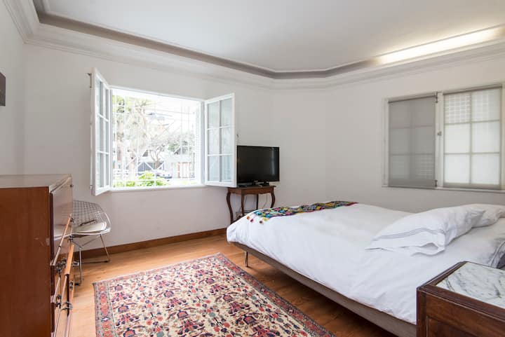 חדר שינה ראשי עם חלונות המשקיפים על הרחוב, המון אור.